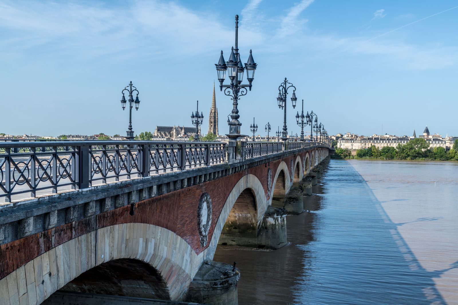 Pont de Pierre stretching across the Garonne in Bordeaux under a blue sky, the gateway to every Bordeaux river cruise